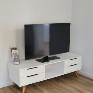 a white entertainment center with a flat screen tv on it at Ferienwohnung Franka in Sonneberg
