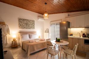 a bedroom with a bed and a table and a kitchen at Cocoon Urban Suites in Kavála
