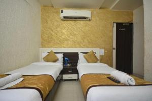 two beds in a hotel room with at Hotel Jasmine in Ahmedabad