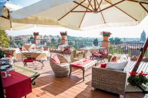 a patio with tables and chairs and an umbrella at La Meridiana Relais in Formello