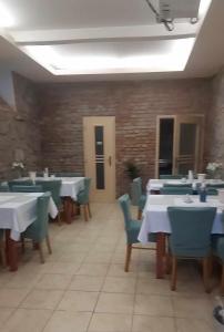a dining room with white tables and blue chairs at Penzion Greenstar in Ústí nad Labem