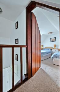 a bedroom with a large wooden door and a bed at Lochead Cottage Ellary in Lochgilphead
