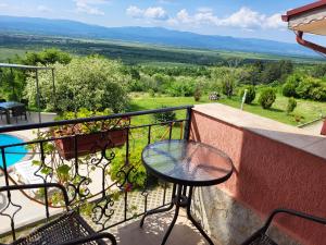 a table and chairs on a balcony with a view at Гледката in Mŭdren
