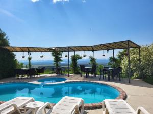 a swimming pool with chairs and a table and a patio at Гледката in Mŭdren