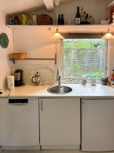 a kitchen counter with a sink and a window at Classic Timber Cottage Close To Forest And Beach in Frederiksværk