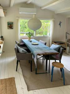 a dining room with a blue table and chairs at Classic Timber Cottage Close To Forest And Beach in Frederiksværk
