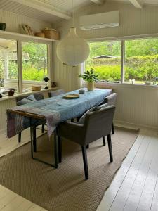 a dining room with a blue table and chairs at Classic Timber Cottage Close To Forest And Beach in Frederiksværk +32 photos