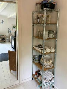a shelf filled with plates and dishes in a kitchen at Classic Timber Cottage Close To Forest And Beach in Frederiksværk