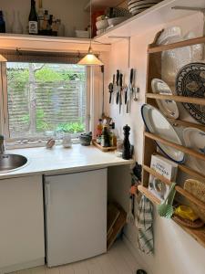 a kitchen with a sink and a counter with dishes at Classic Timber Cottage Close To Forest And Beach in Frederiksværk