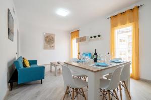 a white dining room with a table and chairs at Cambrils Turistic 3a in Cambrils