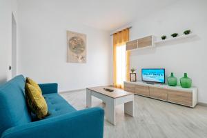 a living room with a blue couch and a table at Cambrils Turistic 3a in Cambrils
