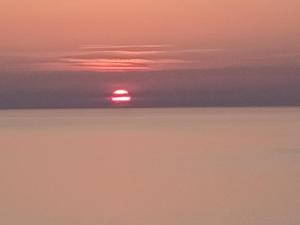 a sunset over the ocean with the sun in the distance at Studio centre de calvi in Calvi