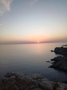 a sunset over a body of water with rocks at Studio centre de calvi in Calvi