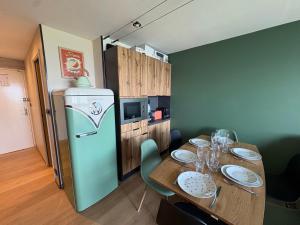 a dining room with a table and a refrigerator at Flocons 48 in Villarembert