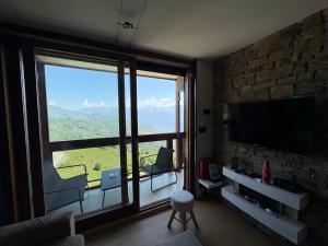 a living room with a large window and a television at Flocons 48 in Villarembert