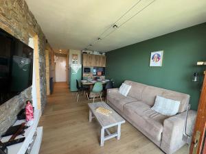 a living room with a couch and a table at Flocons 48 in Villarembert