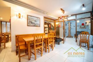 a dining room with a wooden table and chairs at Casa Es Neres in Les