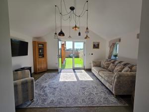 a living room with a couch and a tv at Sunnie view lodge 2 bedroom in Lound