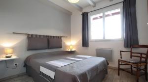 a bedroom with a bed and a window and a chair at Gite Karrikartea in Saint-Pée-sur-Nivelle