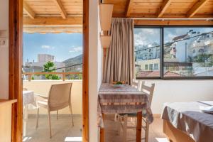 a room with a table and chairs and a balcony at Nikos House in Ierapetra