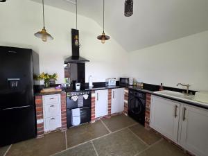 a kitchen with white cabinets and a black refrigerator at Sunnie view lodge 2 bedroom in Lound