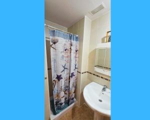 a bathroom with a sink and a shower curtain at Miramar Playa confortable apartament in Miramar