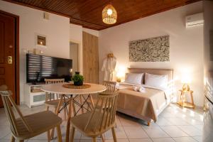 a bedroom with a bed and a table and chairs at Cocoon Urban Suites in Kavála