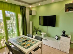 a dining room with a table with chairs and a television at 4 seasons relax apartment in Costa Del Silencio