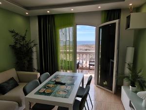 a living room with a table and a view of the ocean at 4 seasons relax apartment in Costa Del Silencio