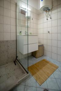 a bathroom with a shower with a sink and a mirror at Cocoon Urban Suites in Kavála +76 photos