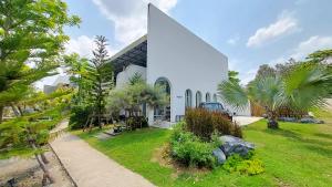 a church with a large white building with palm trees at LK Resort in Ban Map Khao Wan