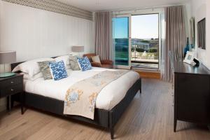 a bedroom with a large bed and a large window at St Moritz Hotel and Cowshed Spa in Polzeath