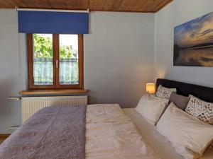 a bedroom with a large bed with a window at Ferienhaus zur Altmühl - Ferienwohnungen & Gartenhäuser in Ornbau