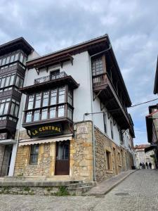 a building with a sign on the side of it at Apartamentos La Botica in Comillas