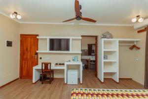 a living room with a desk and a ceiling fan at Blackstone Beach Resort in Uroa