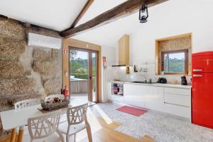 a kitchen with a red refrigerator and a table at Casa do Moinho in Aboim