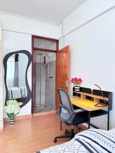 a bedroom with a desk and a shower and a chair at The best west residence in Ruaka