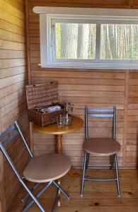 a table and two chairs in a cabin with a window at The lake house in Mockava