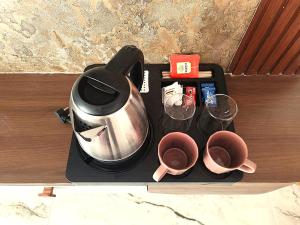 a tea kettle and two cups on a tray at Newly Launched Servostay Luxe Botique Hotel Near Miyapur Metro in Lingampalli