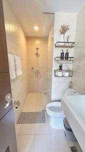 a white bathroom with a shower and a toilet at Jaystaycation in Iloilo City