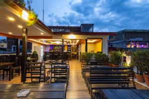 a restaurant with wooden benches and tables on a patio at Hotel Outfitter Nepal in Kathmandu