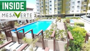 a swimming pool in the middle of a building at D Grey Pillows - 16th Floor One-Bedroom Condo Unit with Sea View in Pontud