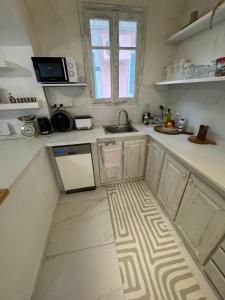 a kitchen with white counters and a sink and a window at Blau Haus Townhouse in Lefkada +24 photos