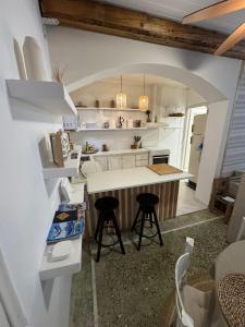 a kitchen with a counter and stools in a room at Blau Haus Townhouse in Lefkada