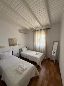 a bedroom with two beds and a window at Eleni's Apartments in Barbati