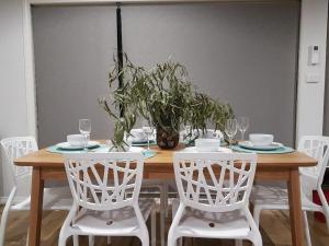 a wooden table with chairs and a vase with plants at Mudita at Bonnie Doon in Bonnie Doon