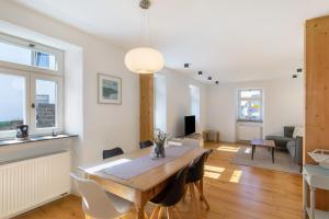a dining room and living room with a table and chairs at Eifel with Family in Thür