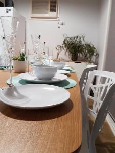 a dining room table with plates and glasses on it at Mudita at Bonnie Doon in Bonnie Doon