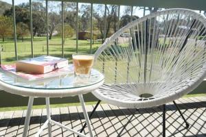 a white chair and a table with a drink on it at Mudita at Bonnie Doon in Bonnie Doon +26 photos