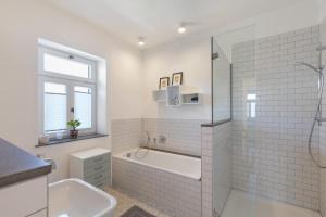 a white bathroom with a tub and a sink at Eifel with Family in Thür +25 photos